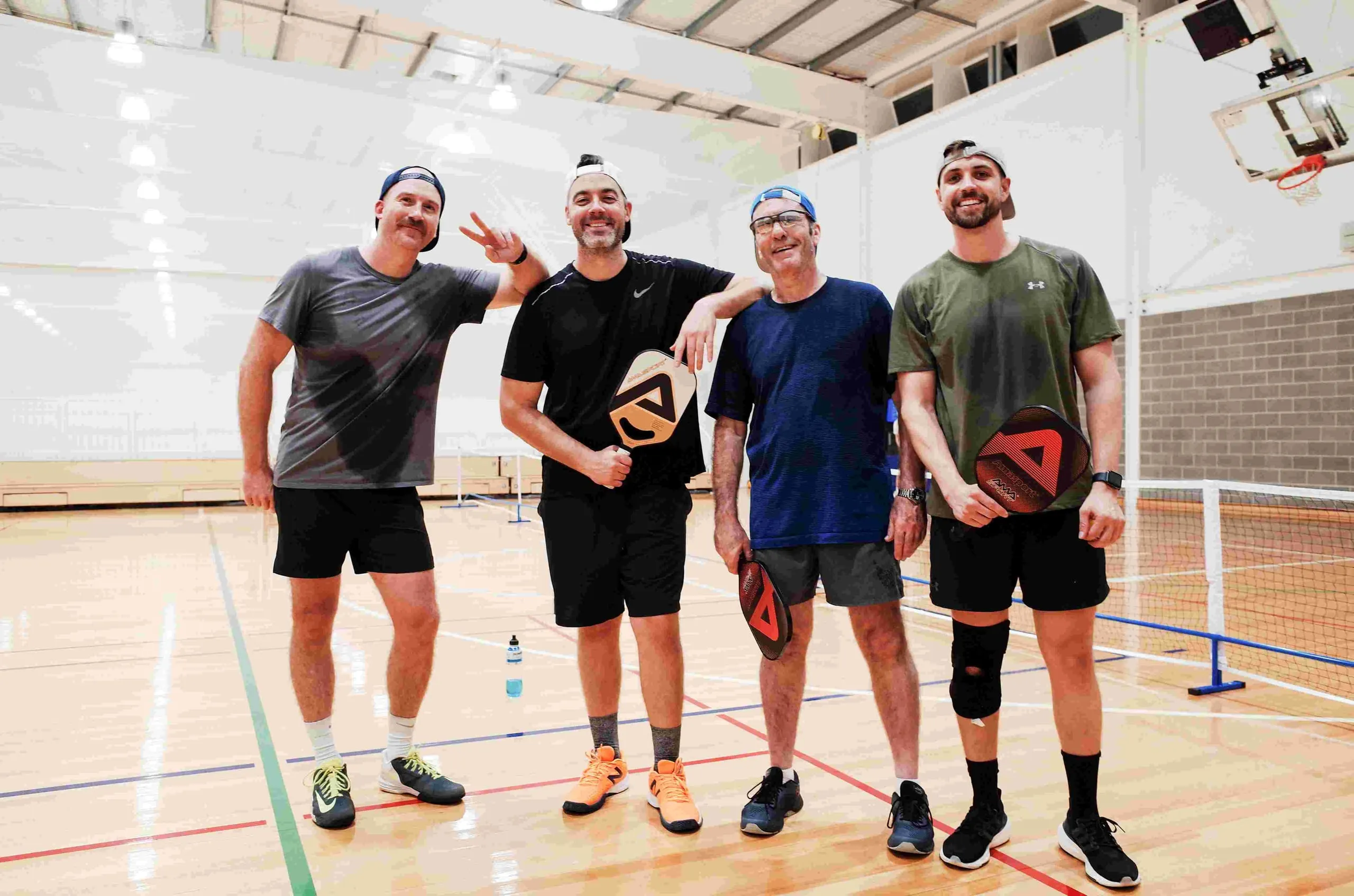 Four Play Pickle players on court with their paddles